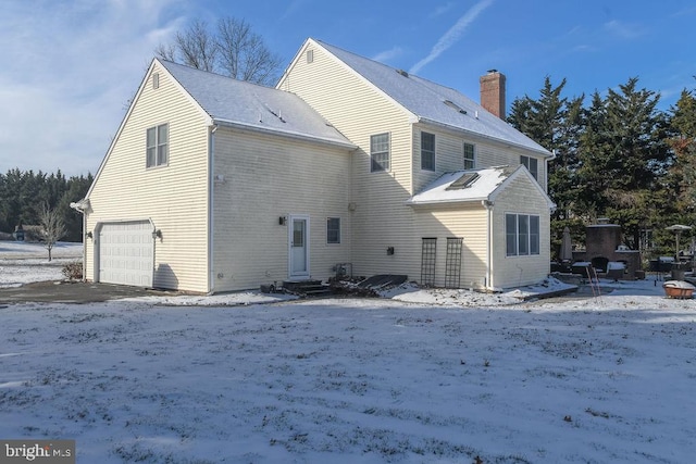 snow covered property featuring a garage