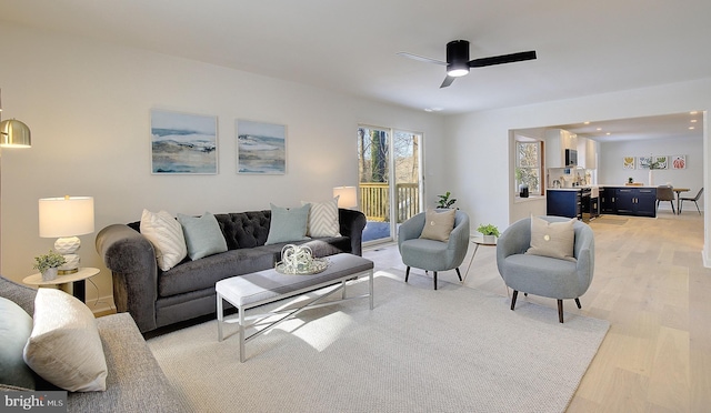 living room featuring light wood-type flooring and ceiling fan