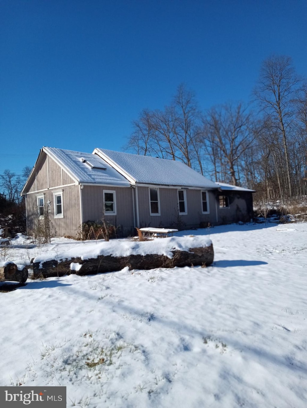 view of snow covered back of property