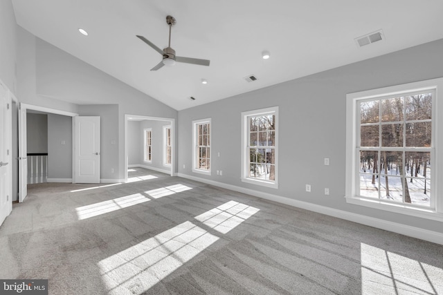 interior space with light carpet, a healthy amount of sunlight, ceiling fan, and high vaulted ceiling