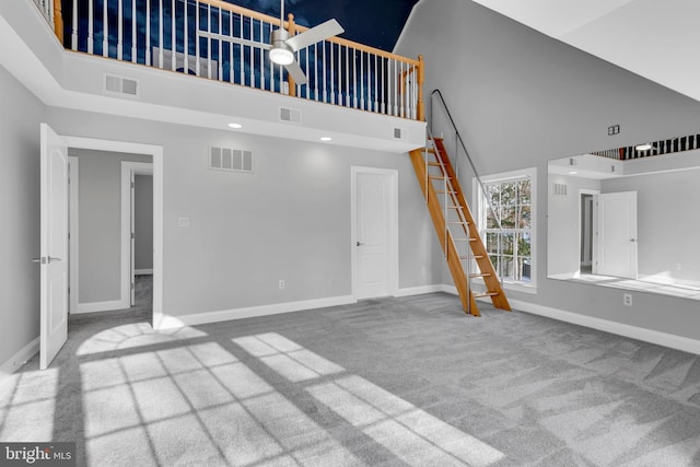 unfurnished living room with carpet and a high ceiling