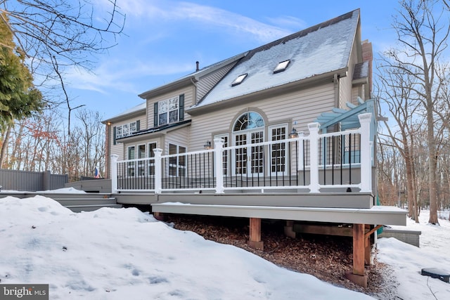 view of snow covered back of property