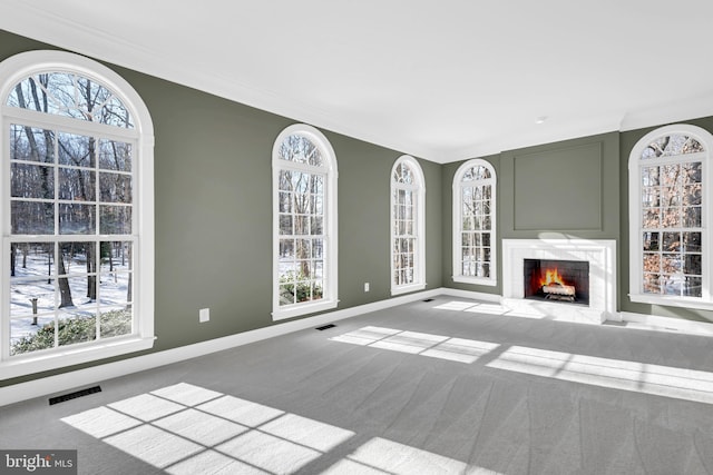 unfurnished living room with a fireplace, a wealth of natural light, and carpet flooring