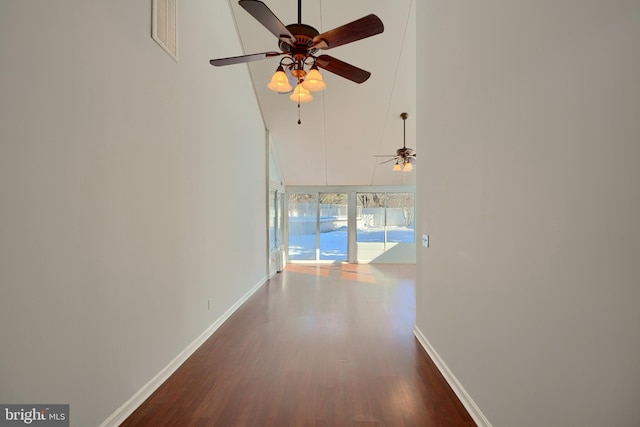 corridor featuring dark wood-type flooring and high vaulted ceiling