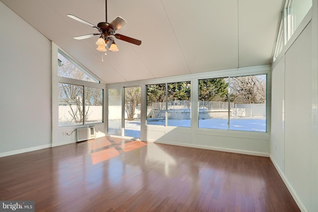 unfurnished sunroom featuring ceiling fan, vaulted ceiling, and a wall unit AC