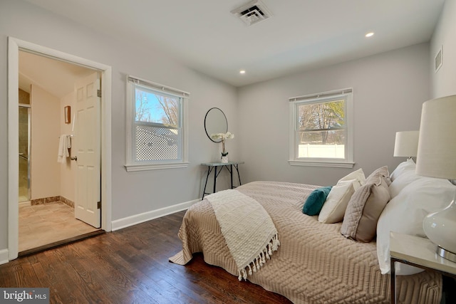 bedroom featuring ensuite bathroom, dark hardwood / wood-style flooring, and multiple windows