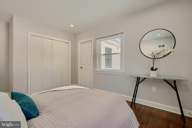 bedroom with dark wood-type flooring and a closet