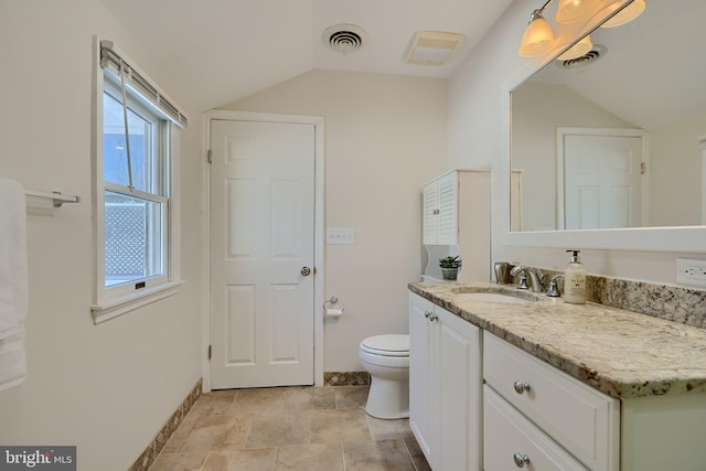 bathroom featuring toilet, vaulted ceiling, and vanity