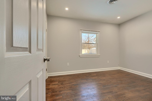 empty room with dark hardwood / wood-style flooring