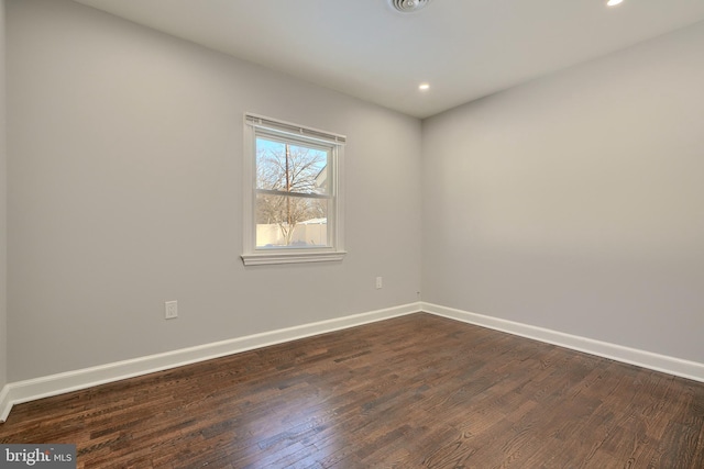 unfurnished room with dark hardwood / wood-style flooring