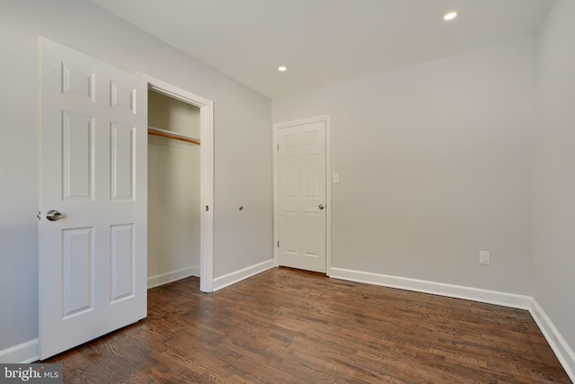 unfurnished bedroom featuring a closet and dark hardwood / wood-style floors