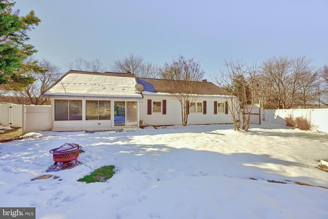 snow covered property with a sunroom and a fire pit