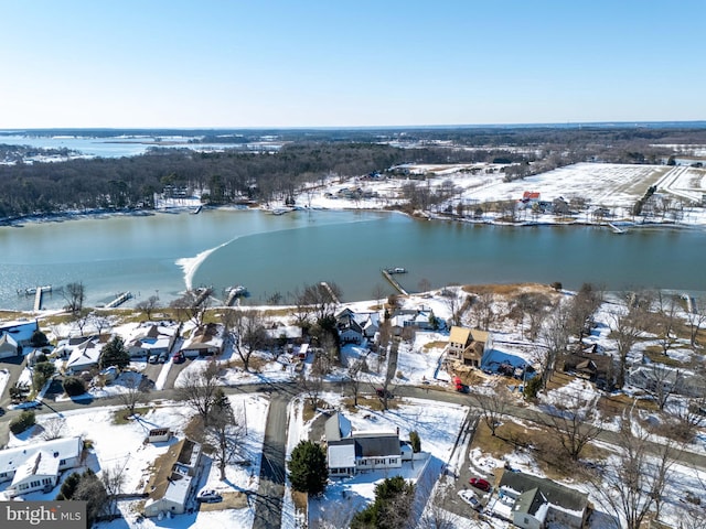 snowy aerial view featuring a water view