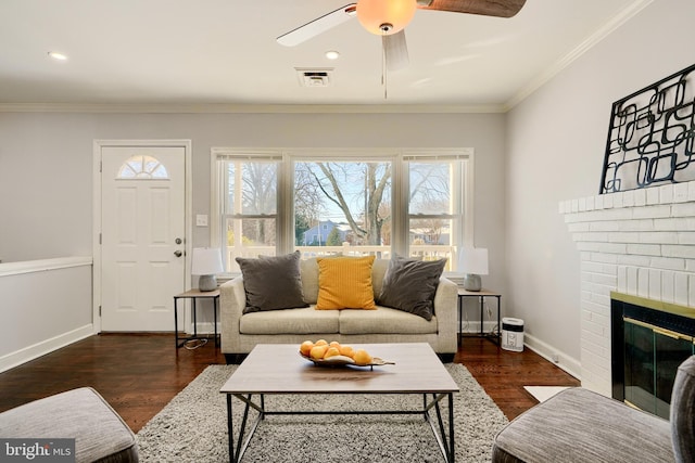 living room featuring a fireplace, ceiling fan, crown molding, and dark hardwood / wood-style floors