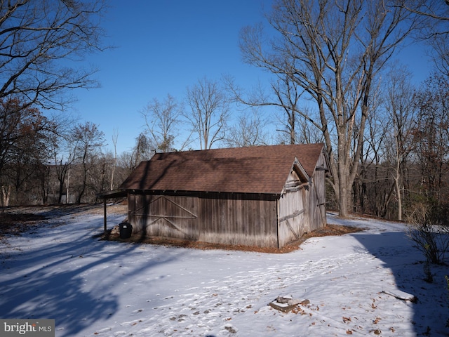 view of snow covered exterior with an outbuilding