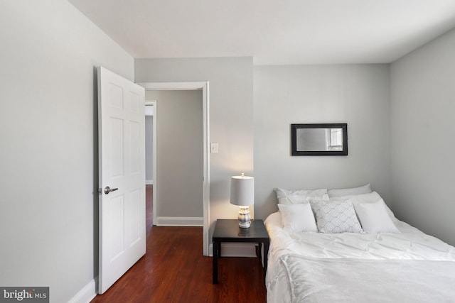 bedroom with dark hardwood / wood-style floors