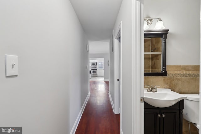 hall with dark hardwood / wood-style floors and sink