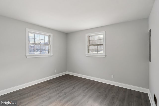 unfurnished room with dark hardwood / wood-style flooring