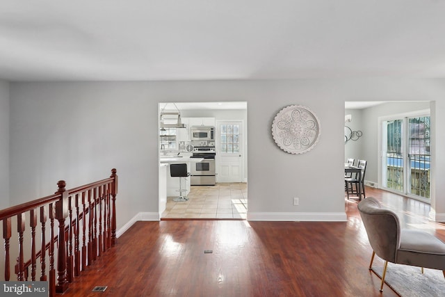 hall with light hardwood / wood-style floors and sink