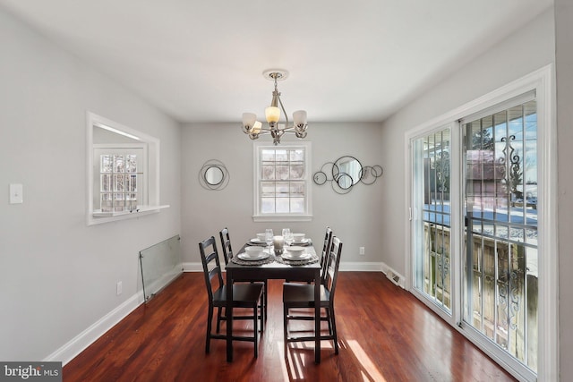 dining area with a notable chandelier and dark hardwood / wood-style flooring