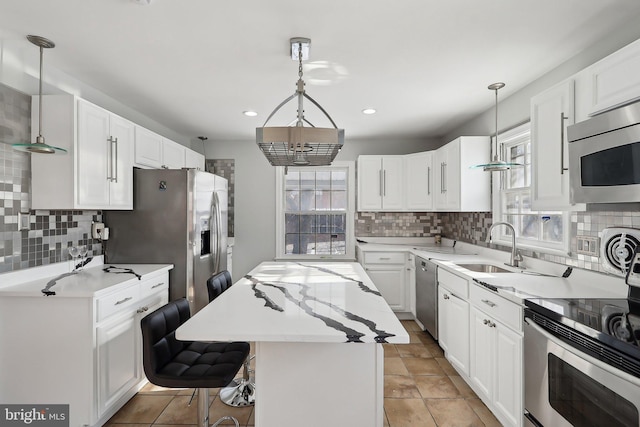 kitchen featuring white cabinetry, hanging light fixtures, and a kitchen island