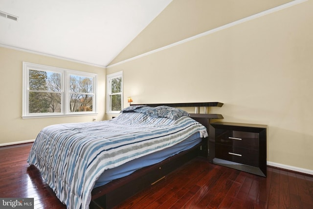 bedroom featuring dark hardwood / wood-style flooring, ornamental molding, and vaulted ceiling