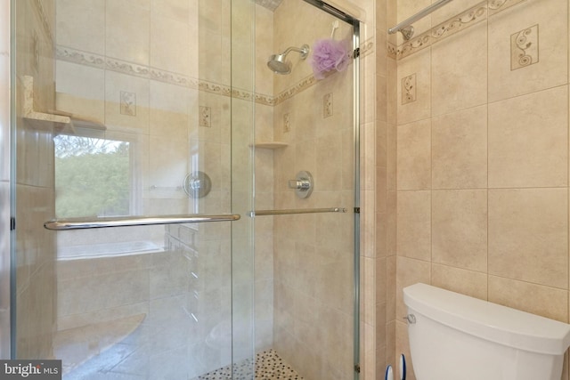 bathroom with toilet, walk in shower, and tile walls