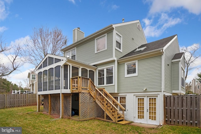 rear view of house featuring a sunroom and a yard