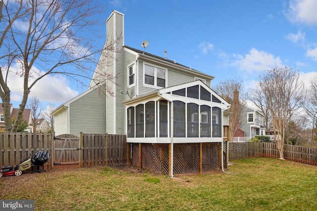 back of property with a yard and a sunroom