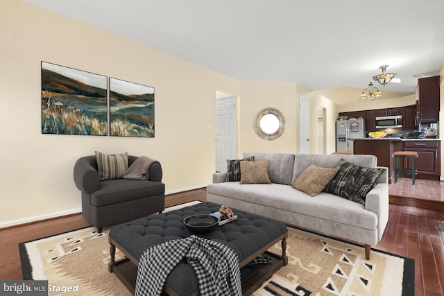 living room featuring wood-type flooring and an inviting chandelier