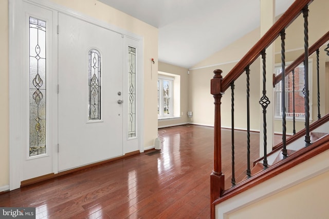 foyer entrance with dark hardwood / wood-style flooring and vaulted ceiling