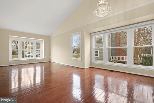 interior space featuring hardwood / wood-style flooring, high vaulted ceiling, and a notable chandelier