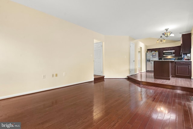 unfurnished living room with dark wood-type flooring and an inviting chandelier