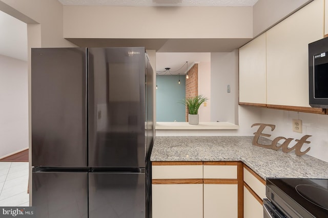 kitchen with light tile patterned floors, white cabinets, and refrigerator