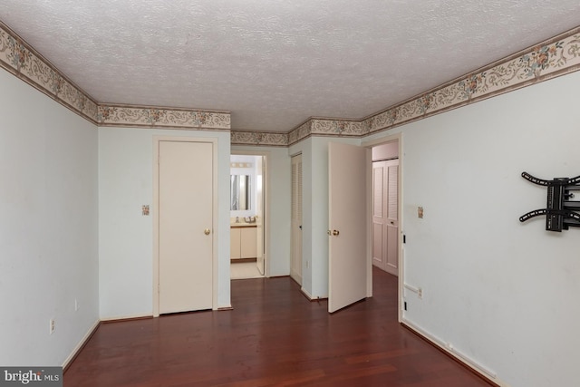 unfurnished room featuring dark hardwood / wood-style flooring and a textured ceiling