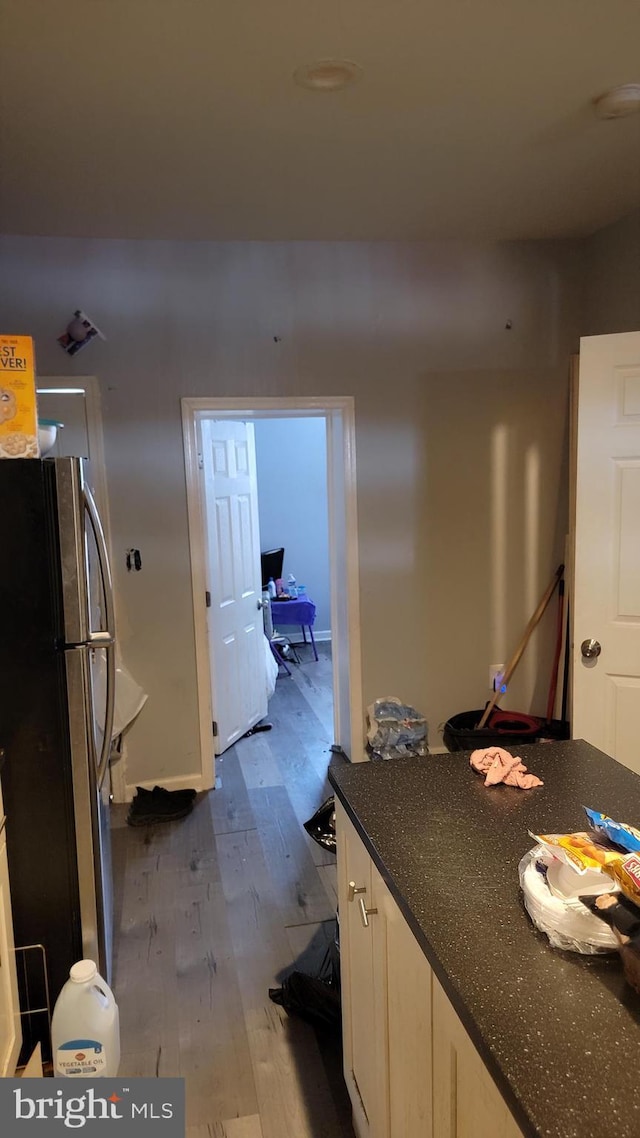 kitchen featuring hardwood / wood-style flooring and stainless steel refrigerator