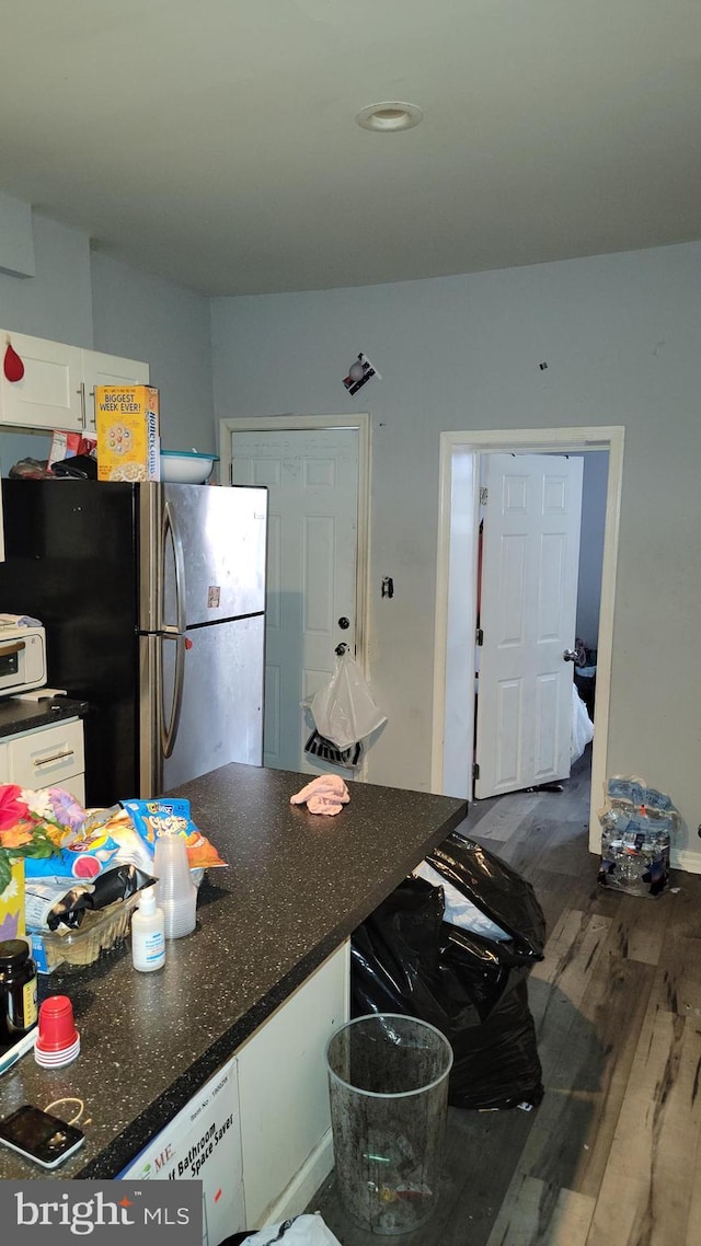 kitchen featuring white cabinets, dark hardwood / wood-style floors, and stainless steel refrigerator