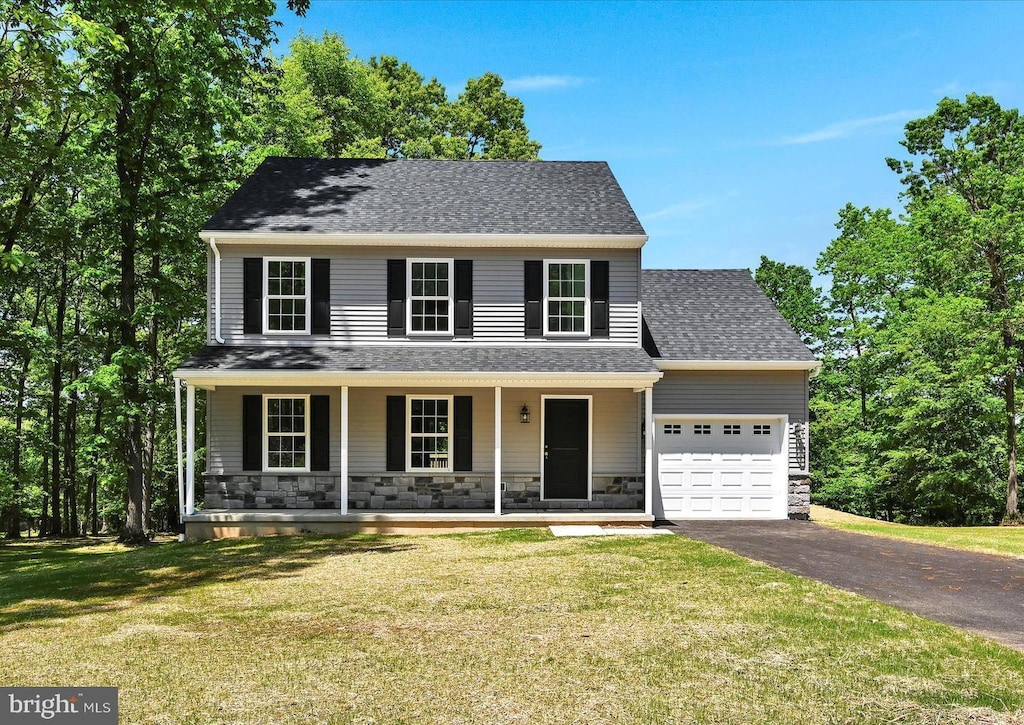 view of front of house featuring a front yard, a porch, and a garage