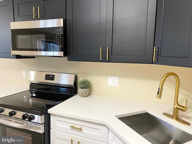 kitchen featuring white cabinets, sink, and appliances with stainless steel finishes