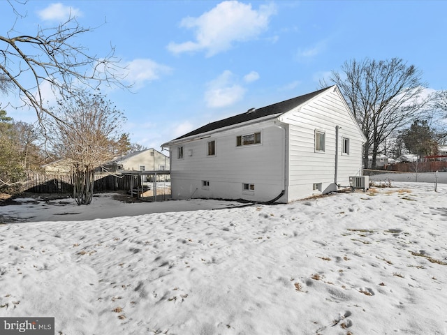 snow covered house with central air condition unit