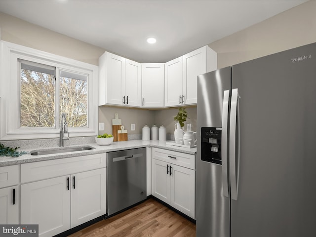 kitchen with appliances with stainless steel finishes, white cabinetry, and sink