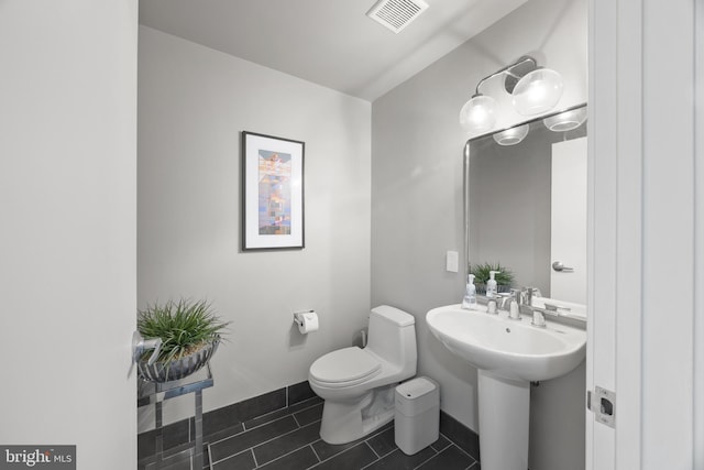 bathroom featuring tile patterned flooring, toilet, and sink