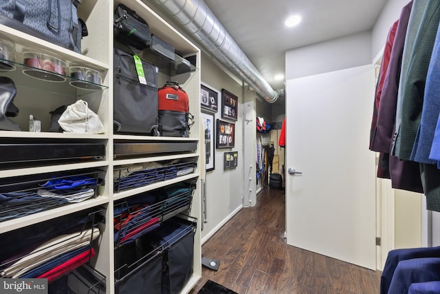 walk in closet with dark hardwood / wood-style flooring