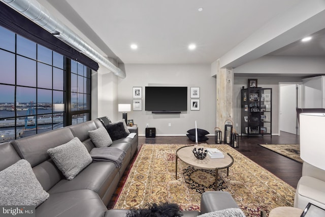 living room with a water view and dark wood-type flooring