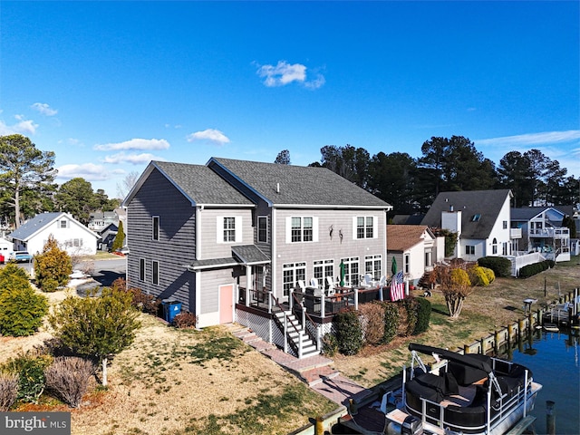 rear view of house featuring a deck with water view