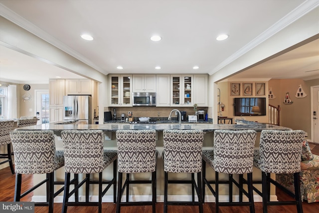 kitchen featuring ornamental molding, a kitchen bar, and stainless steel appliances