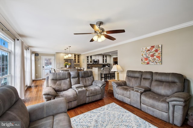 living room with hardwood / wood-style flooring, ceiling fan, and crown molding