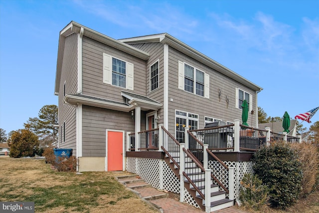 view of front of house with a wooden deck and a front yard