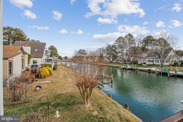 dock area with a water view and a yard