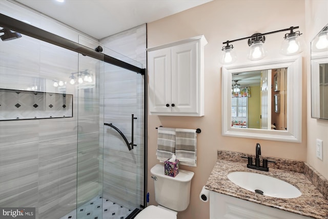 bathroom with vanity, toilet, and a shower with door